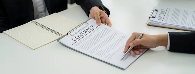 Two business executive in boardroom discuss term and company merging agreement, review corporate...