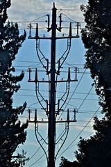Silhouette of Three tier electrical transmission pole with prefabricated auxiliary equipment 