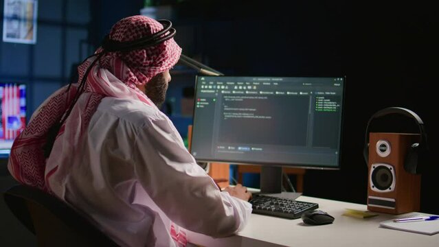 Trained muslim engineer writing code on computer screen while in office using Java programming languages. Middle Eastern developer working on fixing database errors while working from personal office