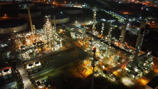 Aerial view of the petrochemical, oil and gas industry. Industrial field, oil refinery storage tanks and steel pipelines at night, ecology and health.	