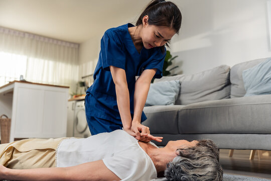 Asian caregiver saving senior woman's life by doing cpr in emergency. 