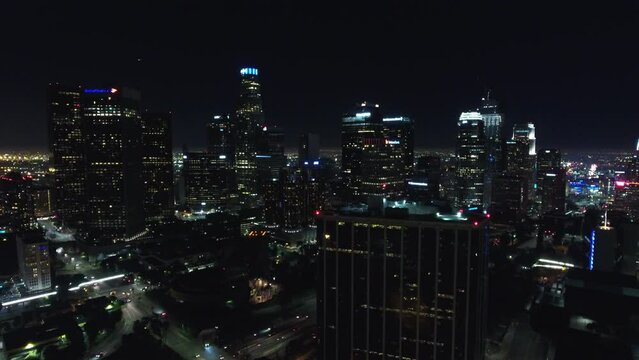 Aerial Forward Shot Of Illuminated Buildings In City Against Sky At Night - Los Angeles, California