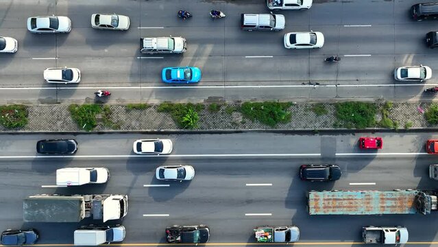An intercity motorway, gridlocked during rush hour, as seen from above by a drone. Endless rows of vehicles, motionless, create a sea of frustration. Road and cars background. Thailand. 4K HDR.
