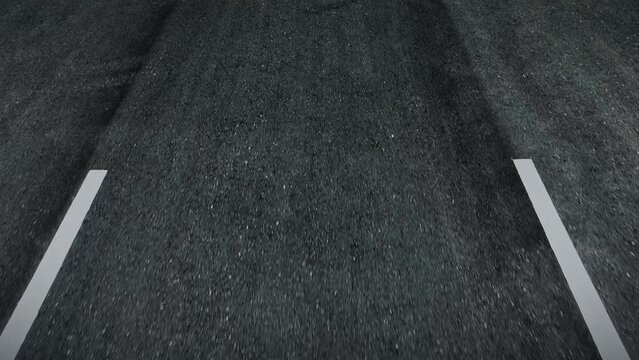 A macro shot captures the asphalt's fine aggregate matrix, newly paved and flawlessly compacted, bearing the weight of a moving vehicle with resilient cohesion. Car and road background. POV.
