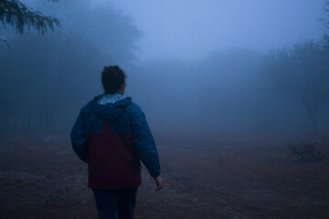 Girl with her back walking towards the fog