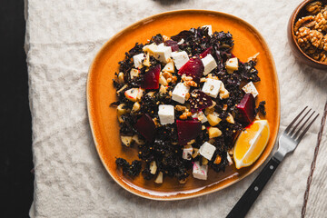 Salad of kale, roasted beets, walnuts and feta cheese on the table top view