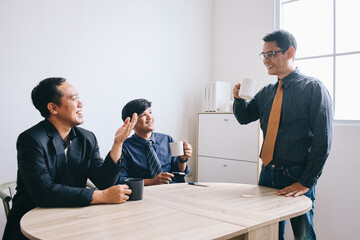 Group of Asian businessman having conversation during break time at office