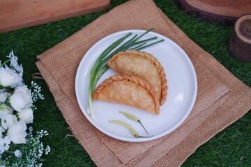 Curry puff or Pastel Goreng is Pastry Popular in Indonesia. fried pastry with filling of sauted vegetable, chicken and boiled egg. accompanied with  sauce or raw chilli pepper