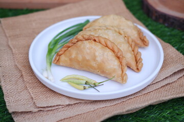Curry puff or Pastel Goreng is Pastry Popular in Indonesia. fried pastry with filling of sauted vegetable, chicken and boiled egg. accompanied with  sauce or raw chilli pepper