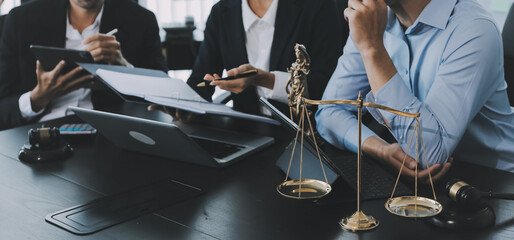 Business and lawyers discussing contract papers with brass scale on desk in office. Law, legal services, advice, justice and law concept picture with film grain effect