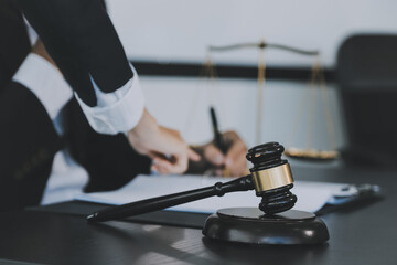 Business and lawyers discussing contract papers with brass scale on desk in office. Law, legal services, advice, justice and law concept picture with film grain effect