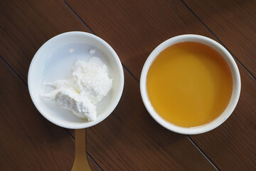 butter cream and honey in a bowl on table .