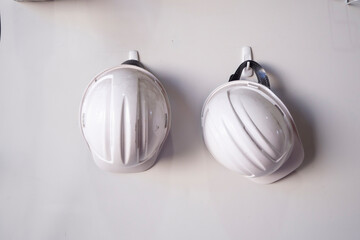 Two white safty hat hang on the wall