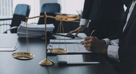 Business and lawyers discussing contract papers with brass scale on desk in office. Law, legal services, advice, justice and law concept picture with film grain effect