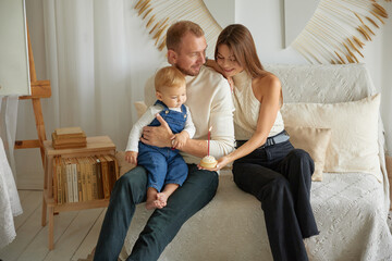 Happy family moments together. Caucasian young happy family nurturing taking care of small little kid child toddler infant baby at home. Parenthood and adoption