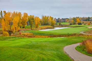 Beautiful golf course in autumn with green grass and trees changing colors near Hudson Wisconsin USA