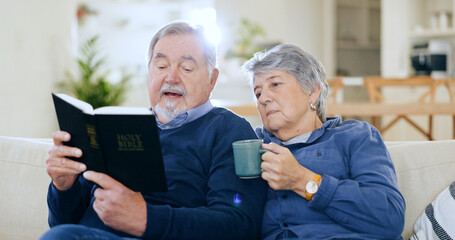 Coffee, bible and a senior couple in their home to read a book together during retirement for...