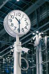 CCTV security camera and public indoor clock in airport terminal, clock shows time for passengers or commuters, shallow depth of field