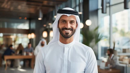 Foto op Plexiglas handsome man with dish dasha working in his business office of Dubai. Portraits of a successful businessman in traditional emirates white dress. © Kowit