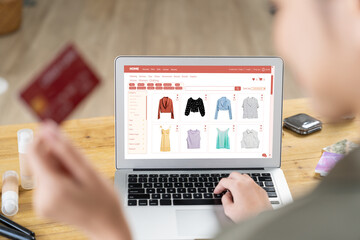 Woman shopping online on internet marketplace browsing for sale items for modern lifestyle and use credit card for online payment from wallet protected by uttermost cyber security software