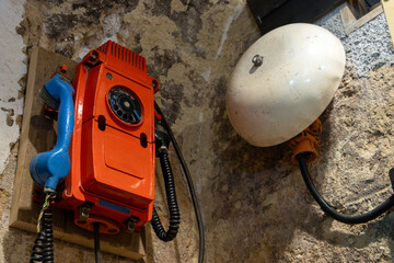 A mine phone with a large bell installed on the wall in the mine