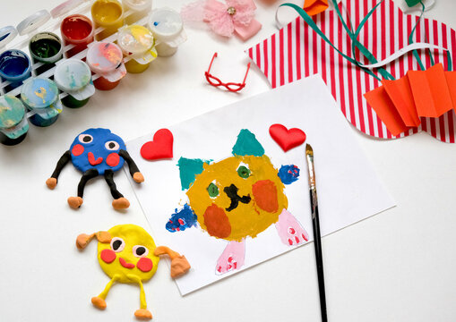 Child painting lovely cat,  hearts, making crafts from paper and plasticine. Handmade concept for birthday, mothers day or Valentines day. Education. Inspiration and imagination