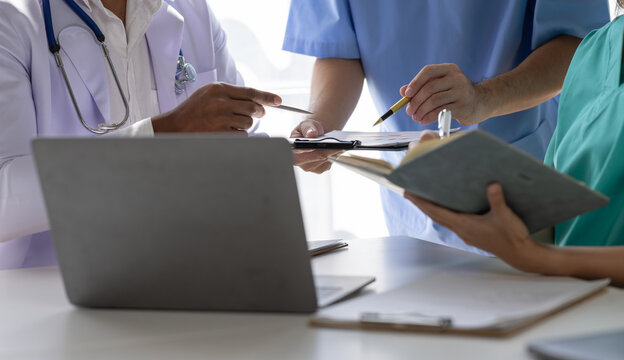 Medical, meeting and healthcare workers  for team in office, discussion, brainstorming and planning. Doctor, nurse and computer on desk show diversity in collaboration or workshop for data analytics