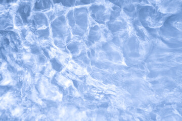 Natural background of water in summer. Blue surface. Clear water with ripples and splashes. water waves in sunlight The water surface has waves.