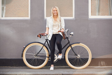 Fototapeta premium Travel, portrait and woman with a bicycle in a city street for vacation, trip or weekend freedom. Adventure, cycling and female person with a bike outdoor for eco transport, fun and exploring London