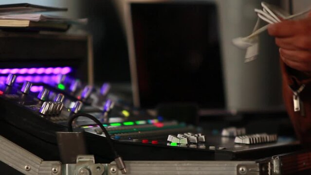 close up, hands of an audio technician untangling audio cable, studio audio mixer, hands of a man with brown skin, hispanic worker
