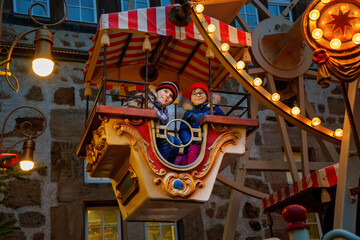 Little preschool girl and school boy riding on ferris wheel carousel horse at Christmas funfair or...