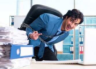 Chained male employee unhappy with excessive work