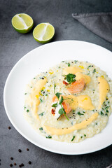 white rice porridge with herbs and fish, side view