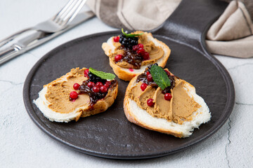 canapes with pate, mint leaves and berries, side view