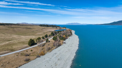 Fototapeta na wymiar Drone photograph of the shore of Lake pukaki and the Snow capped Southern Alps peaks in the background