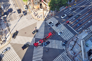 銀座スクランブル交差点を通過する赤い車両 - obrazy, fototapety, plakaty