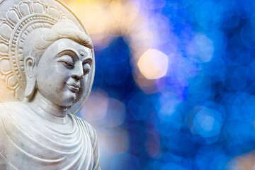 white jade Buddha statue on natural bokeh blurred background, buddha face, big buddha