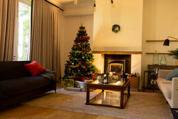 Decorated christmas tree by fireplace in homely living room, copy space