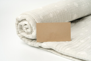 Warm cotton muslin blanket with paper tag on white background