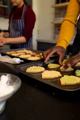  Midsection of diverse couple preparing christmas cookies in kitchen, copy space © wavebreak3