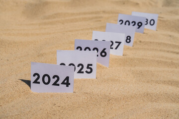 Paper cards with numbers of years from 2024 to 2030 in a row. New year start concept. Resolution time is flying plan goal motivation countdown
