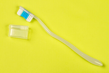 Toothbrush with cap on green background. Modern toothbrush close-up.