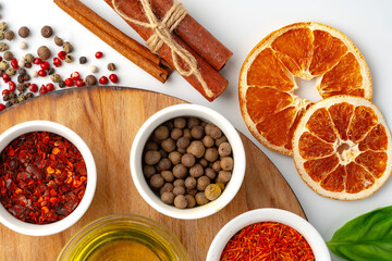 Bowls with spices on wooden board on white background