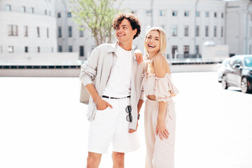 Portrait of young smiling beautiful woman and her handsome boyfriend in casual summer clothes. Happy cheerful family. Female having fun. Couple posing in the street background at sunny day