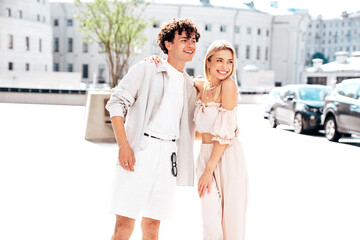 Portrait of young smiling beautiful woman and her handsome boyfriend in casual summer clothes. Happy cheerful family. Female having fun. Couple posing in the street background at sunny day
