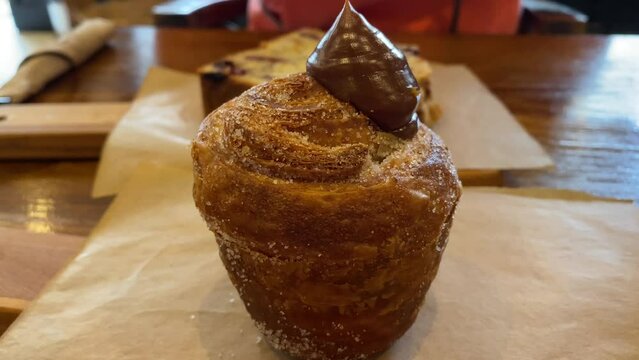 Delicious cruffin with chocolate, a mix of croissant and a muffin with caramel, sweet breakfast pastry, 4K shot