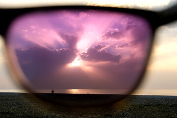 View on seascape sea and sunset sky through polarizing purple sunglasses. Scenery landscap. Man...