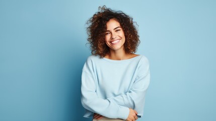 American woman standing in front of a blue background, showing a cheerful and caring smile. Romantic concept.