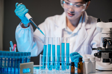 Female Research Scientist Uses Micropipette Filling Test Tubes in Modern Laboratory.