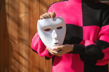 Caucasian young woman showing white face mask.